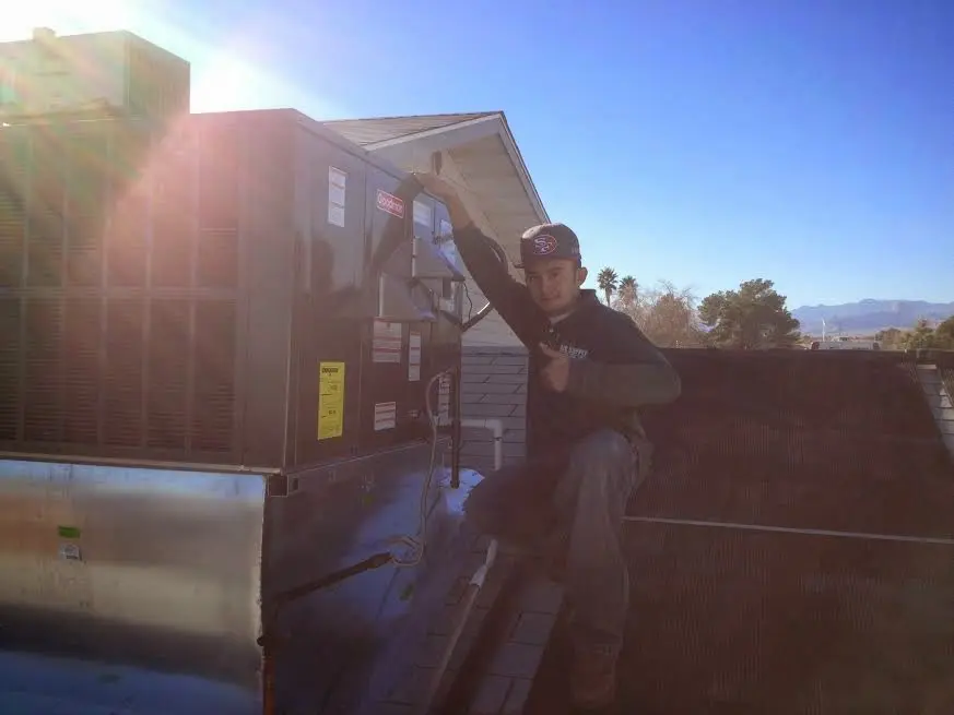 HVAC technician performing Air Duct Cleaning on a rooftop unit in Rupert